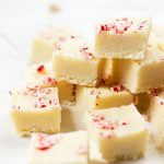 White fudge is topped with peppermint candy pieces and cut into squares.